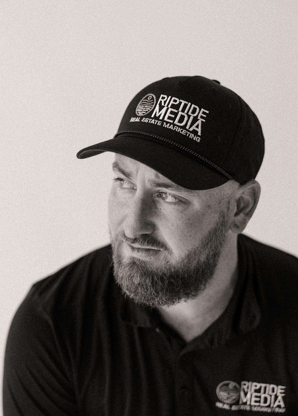 Black-and-white portrait of photographer Jimmy Warr in a ball cap, looking off to the side