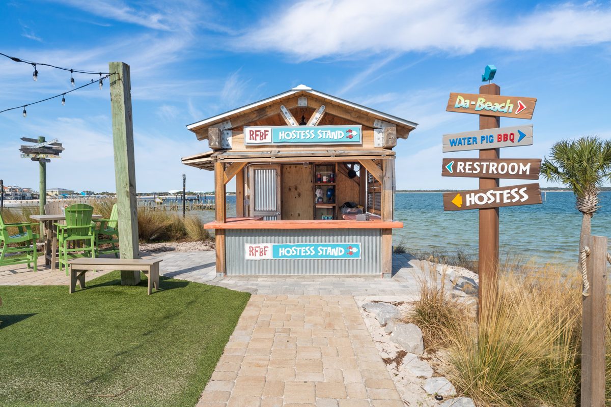 The RFBF hostess stand on the waterfront, signposts pointing to Da-Beach and Water Pig BBQ — photo by Jimmy Warr