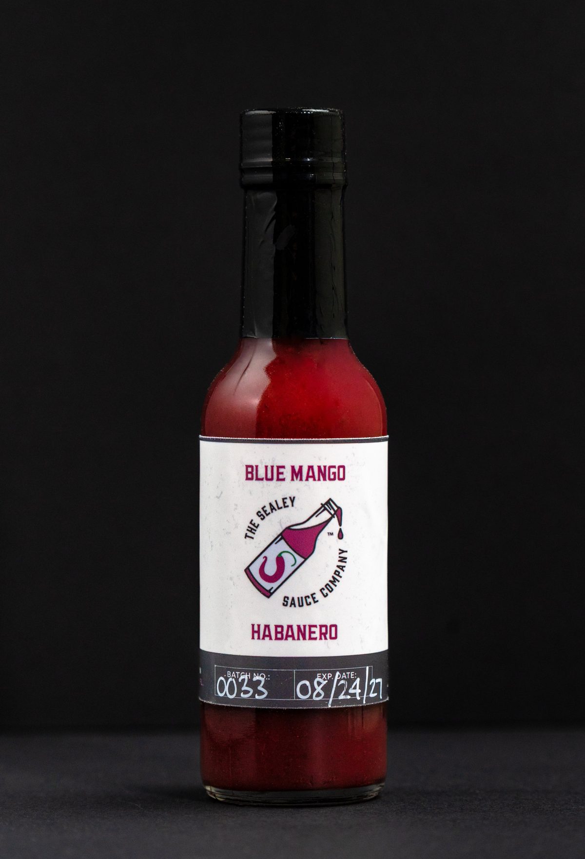 The Sealey Sauce Company Blue Mango Habanero hot sauce on black — photo by Jimmy Warr