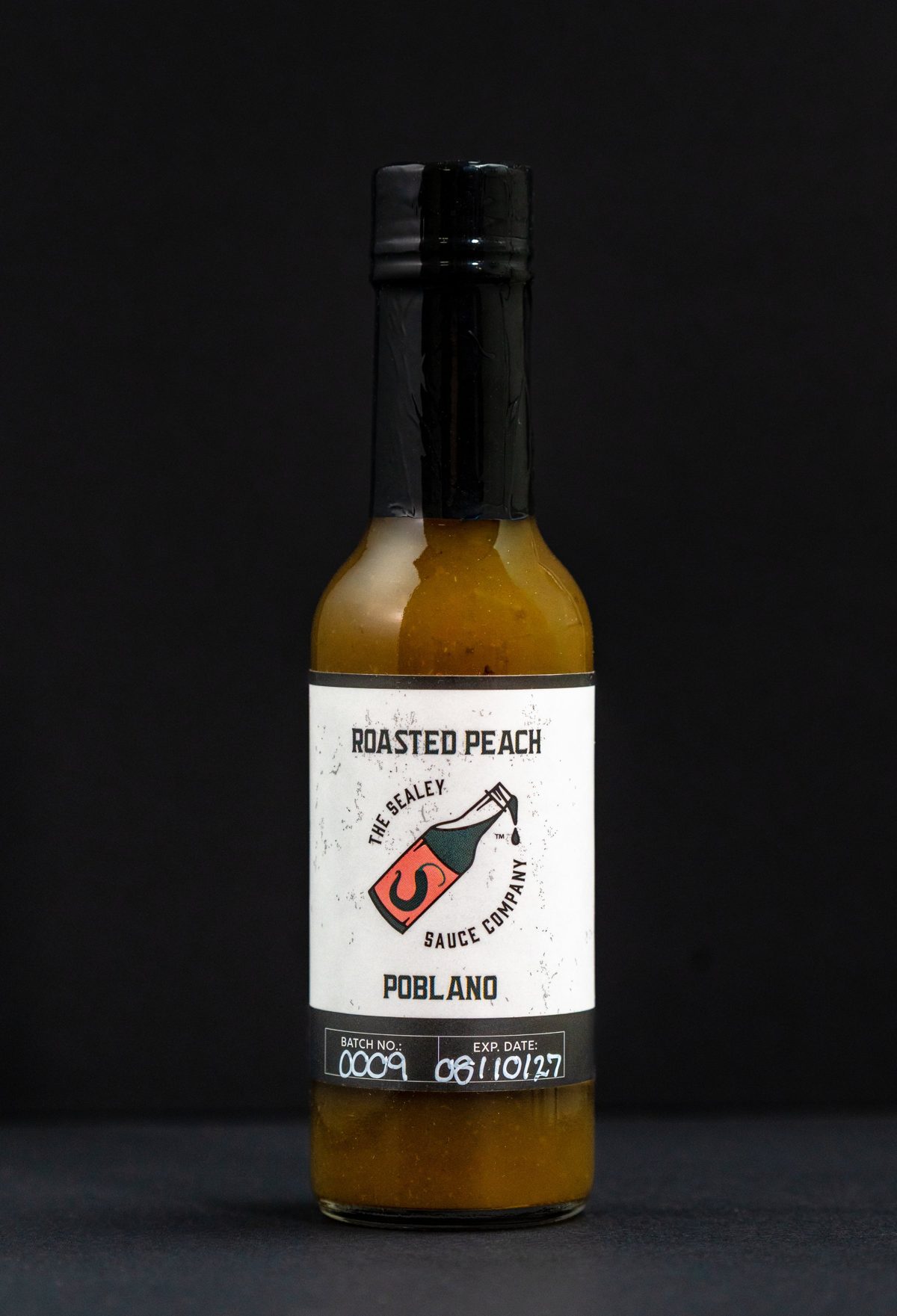 The Sealey Sauce Company Roasted Peach Poblano hot sauce on black — photo by Jimmy Warr
