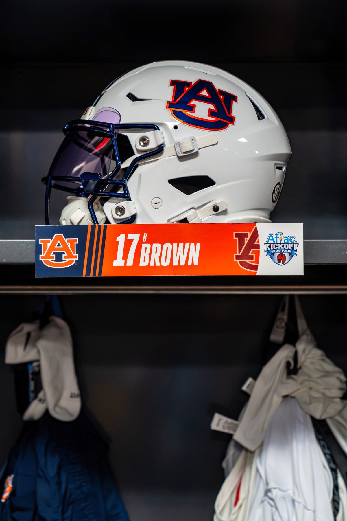 Auburn helmet on a locker shelf above B. Brown's Aflac Kickoff Game nameplate — photo by Jimmy Warr