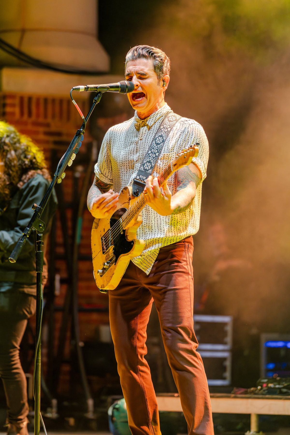 Dashboard Confessional frontman belting a chorus in warm amber light — photo by Jimmy Warr
