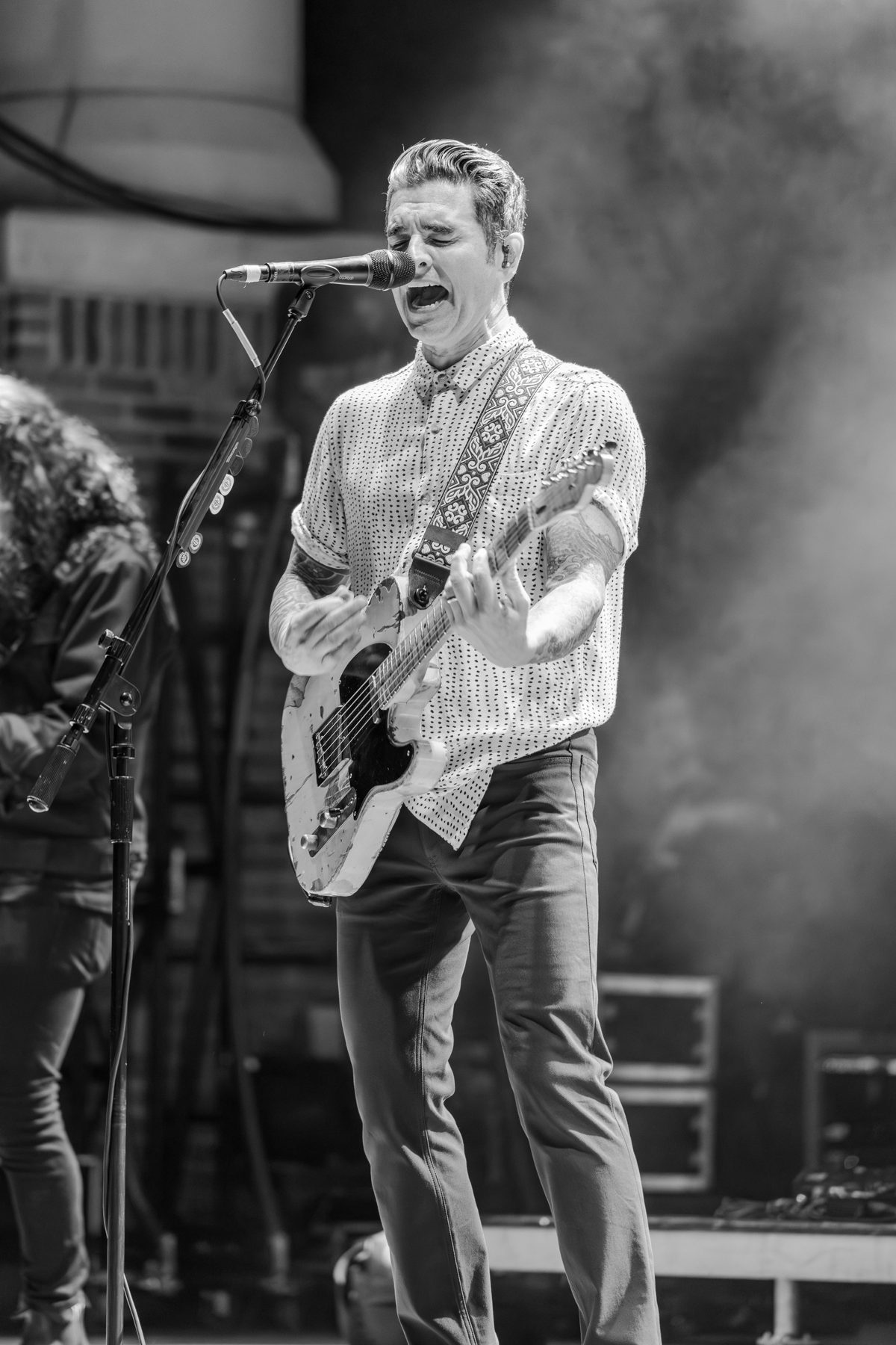 Black-and-white frame of the Dashboard Confessional frontman belting a chorus — photo by Jimmy Warr
