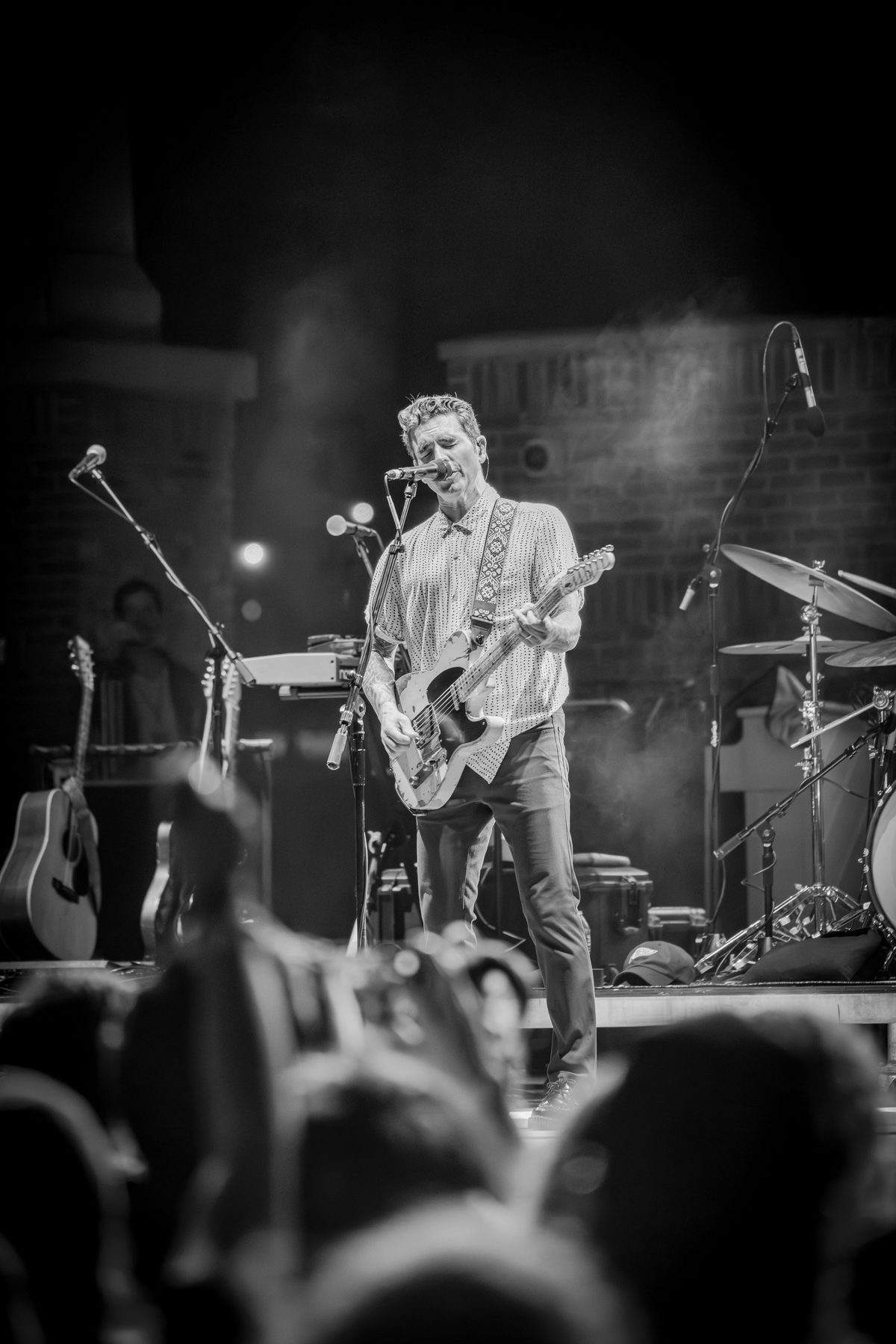 Black-and-white view of Dashboard Confessional from deep in the crowd — photo by Jimmy Warr